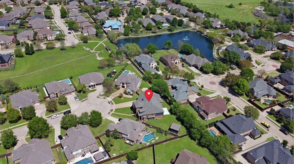 1750 Greenwood Court, Prosper, TX 75078 Aerial perspective of a residential neighborhood featuring established homes, mature trees, and a central pond
