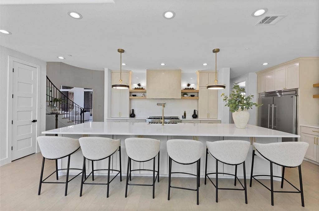 1750 Greenwood Court, Prosper, TX 75078 Spacious kitchen island with a white countertop, recessed lighting, stainless steel refrigerator, and gold-tone kitchen fixtures