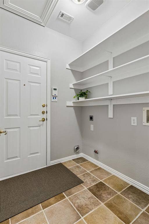 Utility room has gas and electrical hookups along with built in shelves