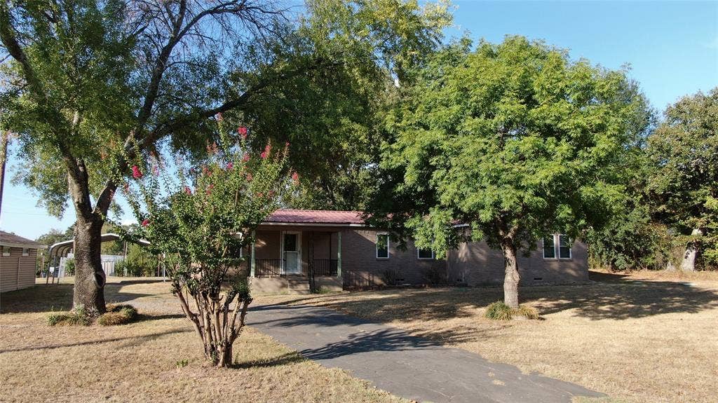 7544 N US HIGHWAY 69 Highway, Alba, TX 75410 Single-story residence with a red metal roof, covered front porch, and multiple windows