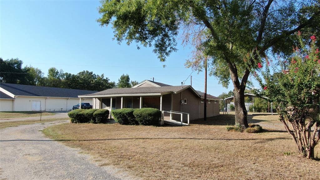 7544 N US HIGHWAY 69 Highway, Alba, TX 75410 Single-story structure with a covered porch, an accessible ramp, and a gravel driveway