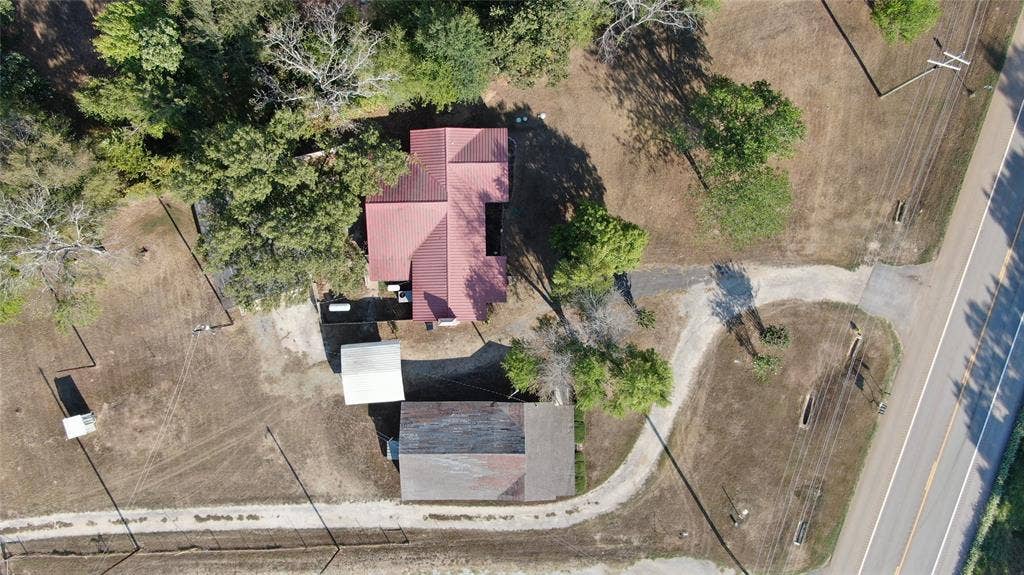 7544 N US HIGHWAY 69 Highway, Alba, TX 75410 Property featuring a red-roofed structure, secondary outbuilding, and expansive cleared land