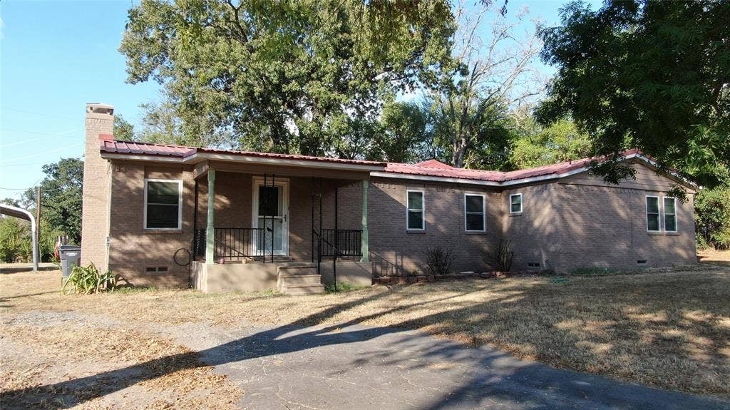 7544 N US HIGHWAY 69 Highway, Alba, TX 75410 Brick exterior with a red metal roof, covered front porch, and a prominent chimney