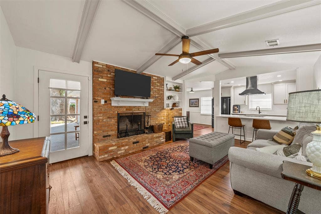 1712 Laurel Lake Drive, Waco, TX 76710 Vaulted ceiling with exposed beams, brick fireplace with mantel, wood-finish flooring, recessed lighting, and built-in shelving