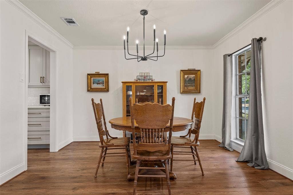 1712 Laurel Lake Drive, Waco, TX 76710 Wood-finish flooring throughout, crown molding, and a modern black chandelier