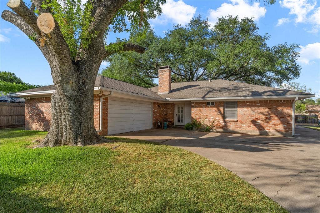 1712 Laurel Lake Drive, Waco, TX 76710 Brick exterior, attached garage, composition shingle roof, mature tree, and concrete driveway