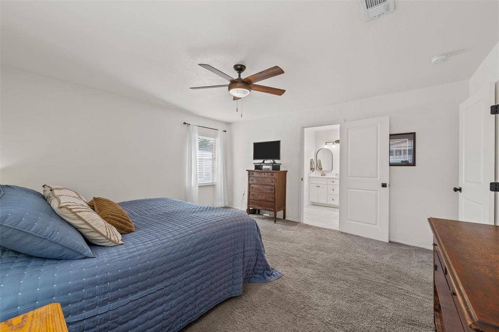 1712 Laurel Lake Drive, Waco, TX 76710 Plush carpet flooring, a ceiling fan with integrated lighting, and a white paneled door leading to a bathroom with a white vanity