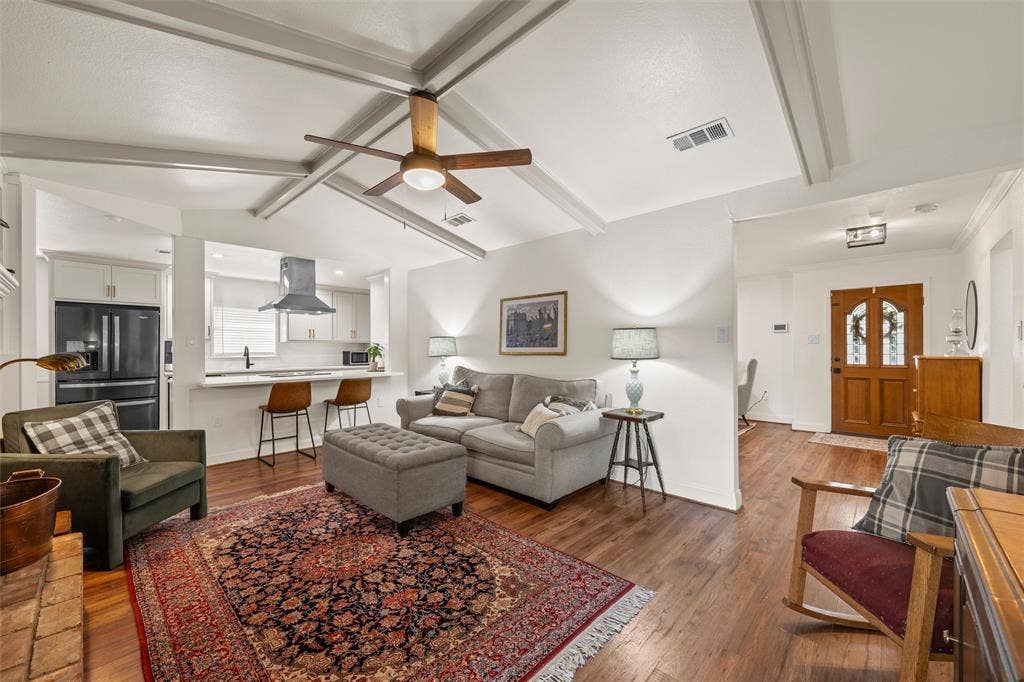 1712 Laurel Lake Drive, Waco, TX 76710 Vaulted ceiling with exposed beams, wood-finish flooring, kitchen with contemporary range hood, breakfast bar, and wood entry door with glass inserts