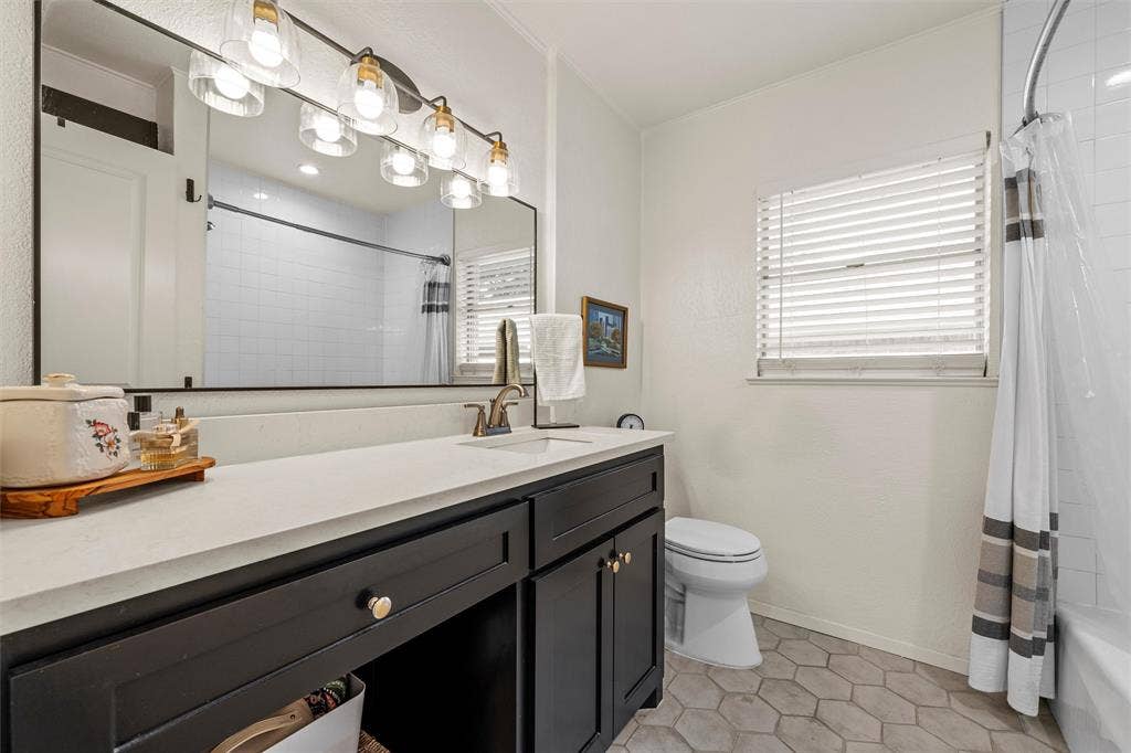 1712 Laurel Lake Drive, Waco, TX 76710 Bathroom featuring a dark wood-finish vanity with a light-toned countertop, a rectangular mirror, and a five-light fixture