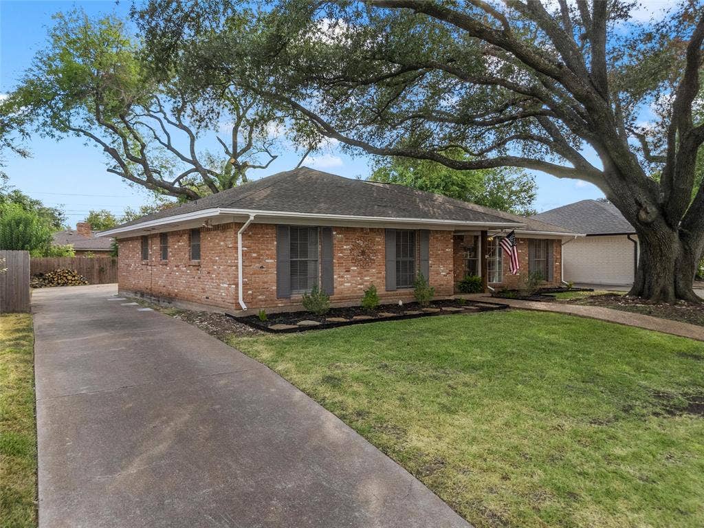 1712 Laurel Lake Drive, Waco, TX 76710 Brick exterior with dark gray shutters, mature front yard tree, established landscaping, and an extended concrete driveway