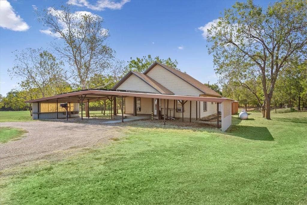 4246 Old Caufield Ranch Road, McGregor, TX 76657 Expansive gravel driveway leading to an attached carport