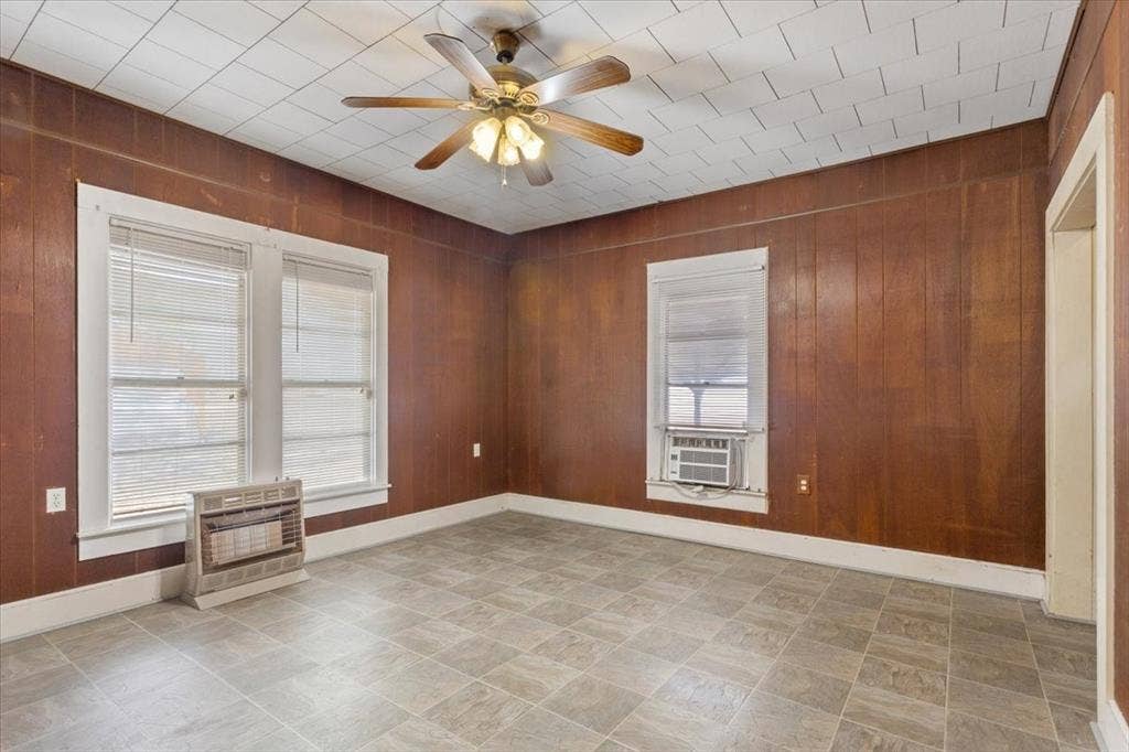 4246 Old Caufield Ranch Road, McGregor, TX 76657 Wood paneling, tiled ceiling, ceiling fan, and multiple windows with blinds
