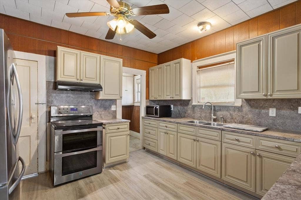 4246 Old Caufield Ranch Road, McGregor, TX 76657 Double electric oven, stainless steel refrigerator, and built in cream colored cabinets