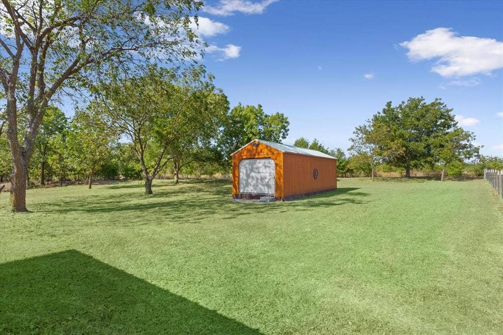 4246 Old Caufield Ranch Road, McGregor, TX 76657 Expansive lawn with mature trees and a detached storage building