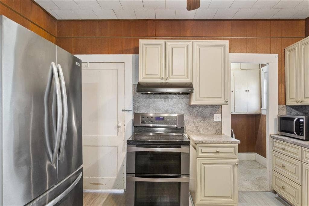 4246 Old Caufield Ranch Road, McGregor, TX 76657 Double electric oven, stainless steel refrigerator, and built-in cream colored cabinets