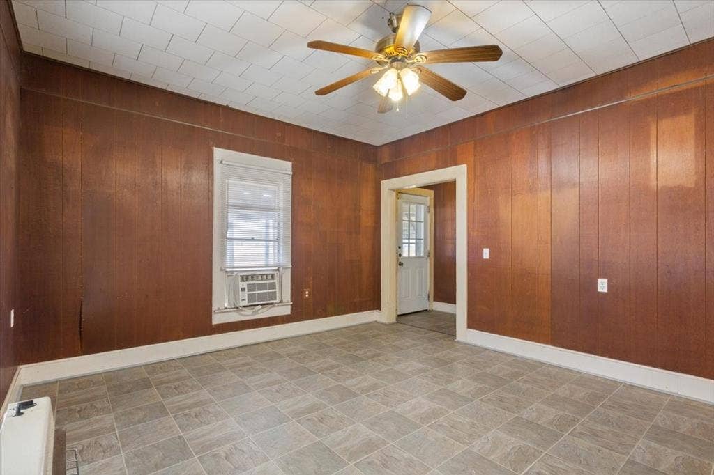 4246 Old Caufield Ranch Road, McGregor, TX 76657 Paneled walls, ceiling fan, and window with an air conditioning unit