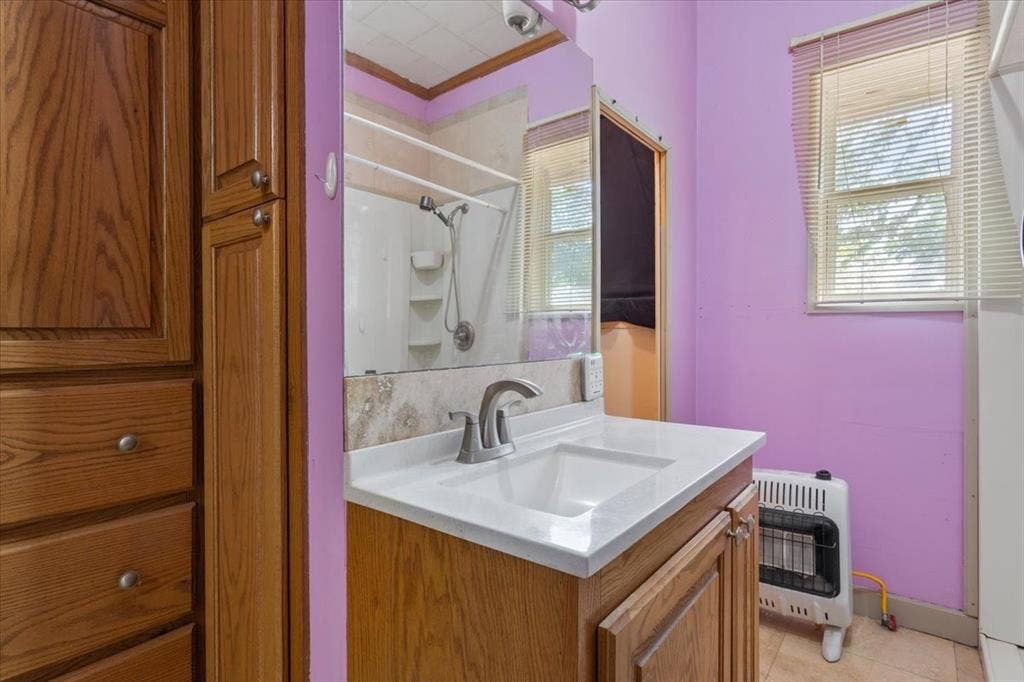 4246 Old Caufield Ranch Road, McGregor, TX 76657 Vanity with an integrated sink and brushed nickel faucet, a medicine cabinet with mirrored door, and a built-in shower