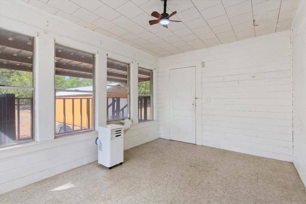 4246 Old Caufield Ranch Road, McGregor, TX 76657 Featuring multiple windows, painted wood panel walls, a ceiling fan, and patterned flooring