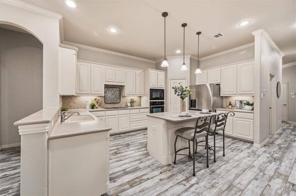 307 Park Haven Boulevard, Euless, TX 76039 Kitchen with white cabinetry, light countertops, wood-finish flooring, recessed lighting, and a kitchen island with pendant lighting