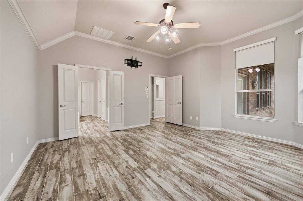 307 Park Haven Boulevard, Euless, TX 76039 Vaulted ceiling with crown molding, wood-finish flooring, ceiling fan with integrated lighting, and multiple windows