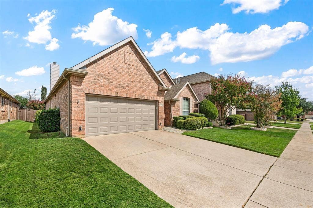 307 Park Haven Boulevard, Euless, TX 76039 Brick exterior with an attached garage, concrete driveway, and established front landscaping
