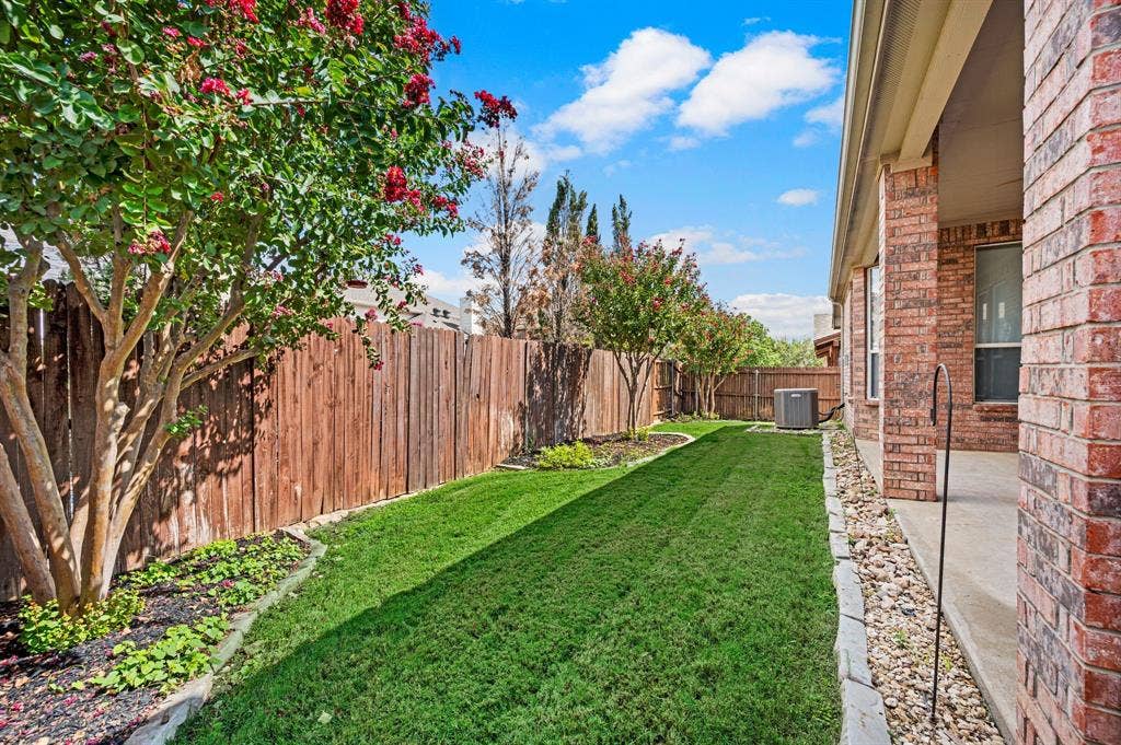 307 Park Haven Boulevard, Euless, TX 76039 Expansive backyard featuring a manicured lawn, wood privacy fencing, and mature trees