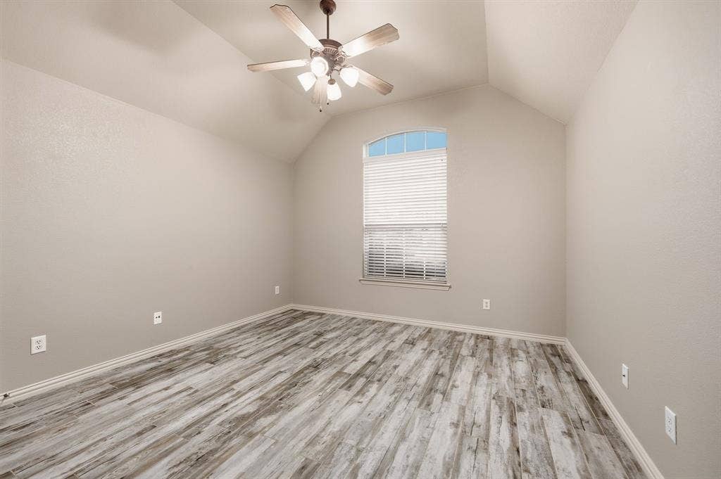 307 Park Haven Boulevard, Euless, TX 76039 Vaulted ceiling with an attached ceiling fan, wood-finish flooring, and an arched window