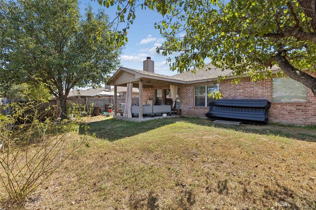 3118 Rosslynn Court, Seagoville, TX 75159 Expansive backyard featuring a covered patio, brick exterior, and mature trees