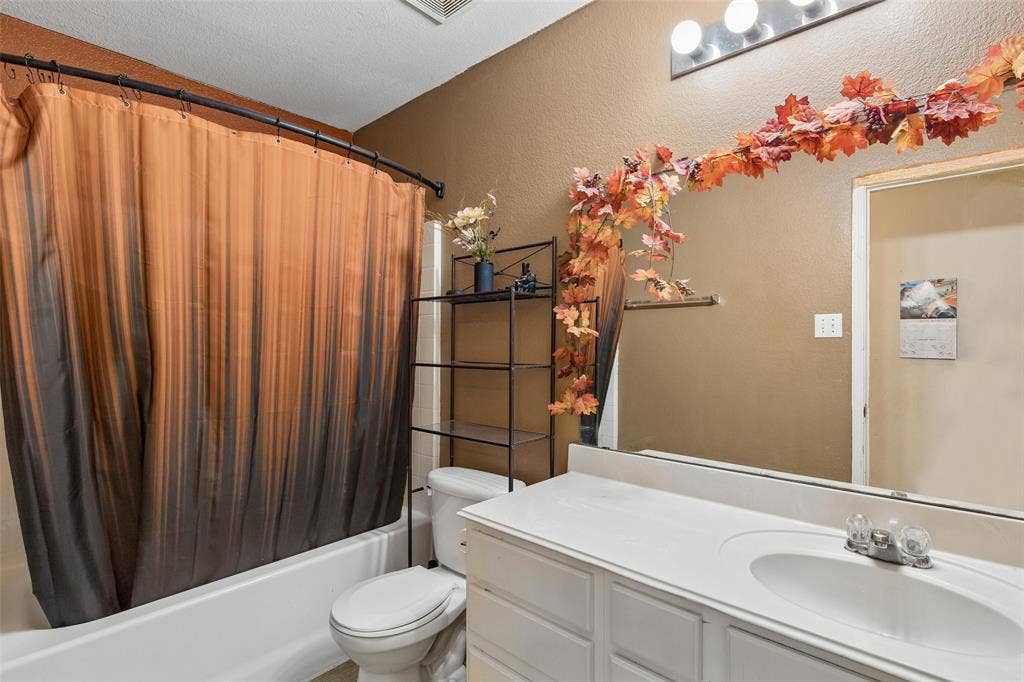 3118 Rosslynn Court, Seagoville, TX 75159 Built-in bathtub, white vanity with integrated sink, wall-mounted light fixture, and a large mirror