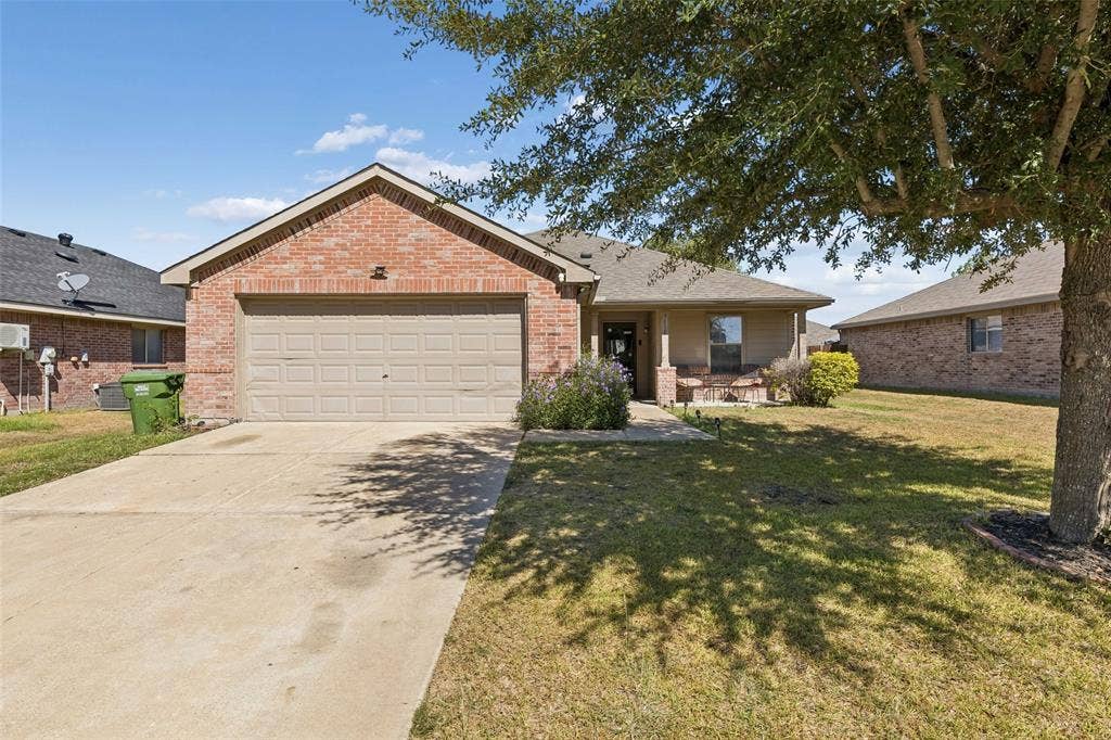 3118 Rosslynn Court, Seagoville, TX 75159 Brick exterior with a gabled roofline, two-car garage, concrete driveway, and covered front porch