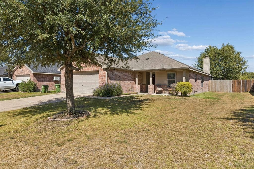 3118 Rosslynn Court, Seagoville, TX 75159 Brick exterior with covered front porch, attached garage, and mature landscaping