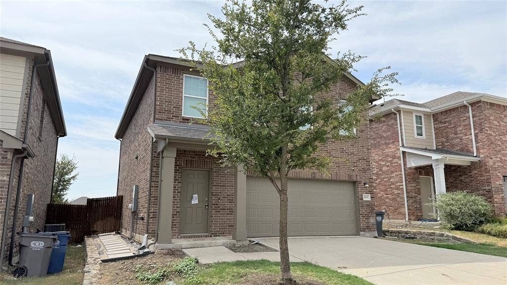 613 Delaware Avenue, Princeton, TX 75407 Brick exterior with an attached garage, covered entry, and a well-maintained tree