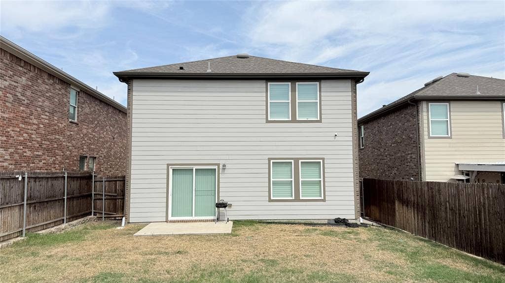 613 Delaware Avenue, Princeton, TX 75407 Two-story residence featuring siding, a sliding glass door, multiple windows, and a concrete patio