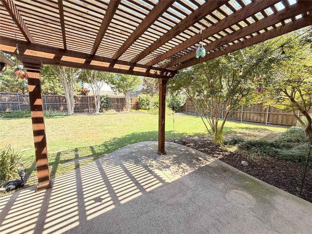 8100 Purple Martin Way, McKinney, TX 75072 Expansive backyard featuring a wood pergola, concrete patio, mature trees, and a wooden fence