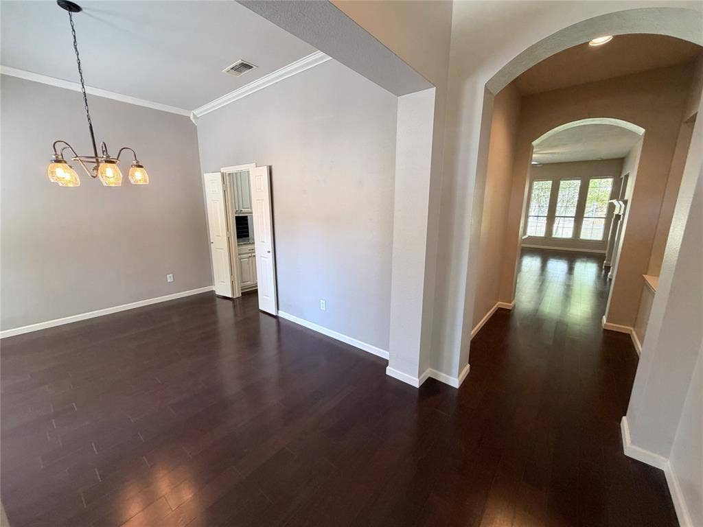 8100 Purple Martin Way, McKinney, TX 75072 Dark wood-finish flooring throughout, vaulted ceiling, crown molding, and an arched entry