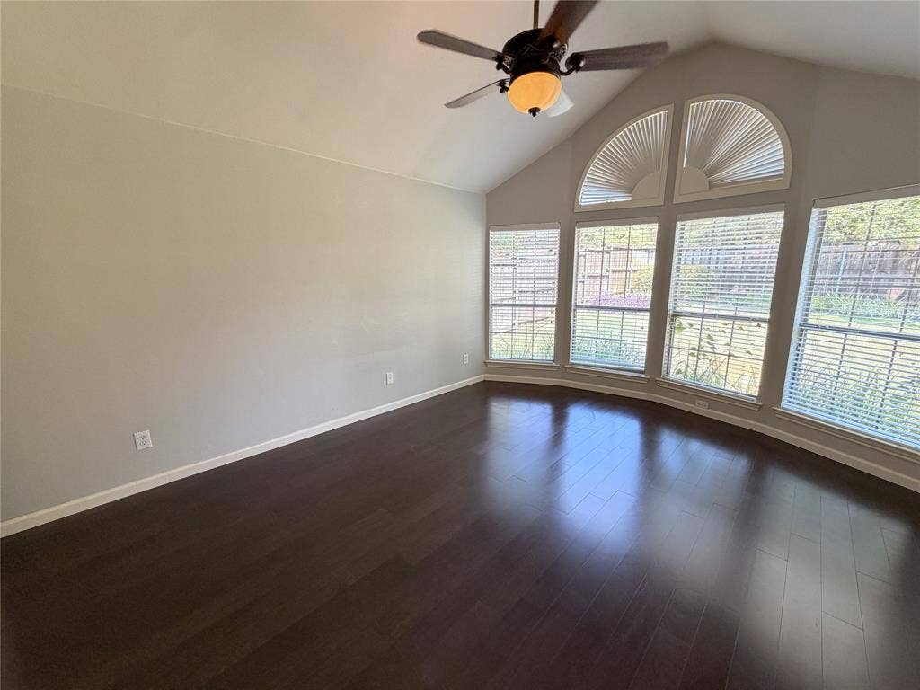 8100 Purple Martin Way, McKinney, TX 75072 Vaulted ceiling featuring a ceiling fan, dark wood-finish flooring, and a bay window with arched transom windows