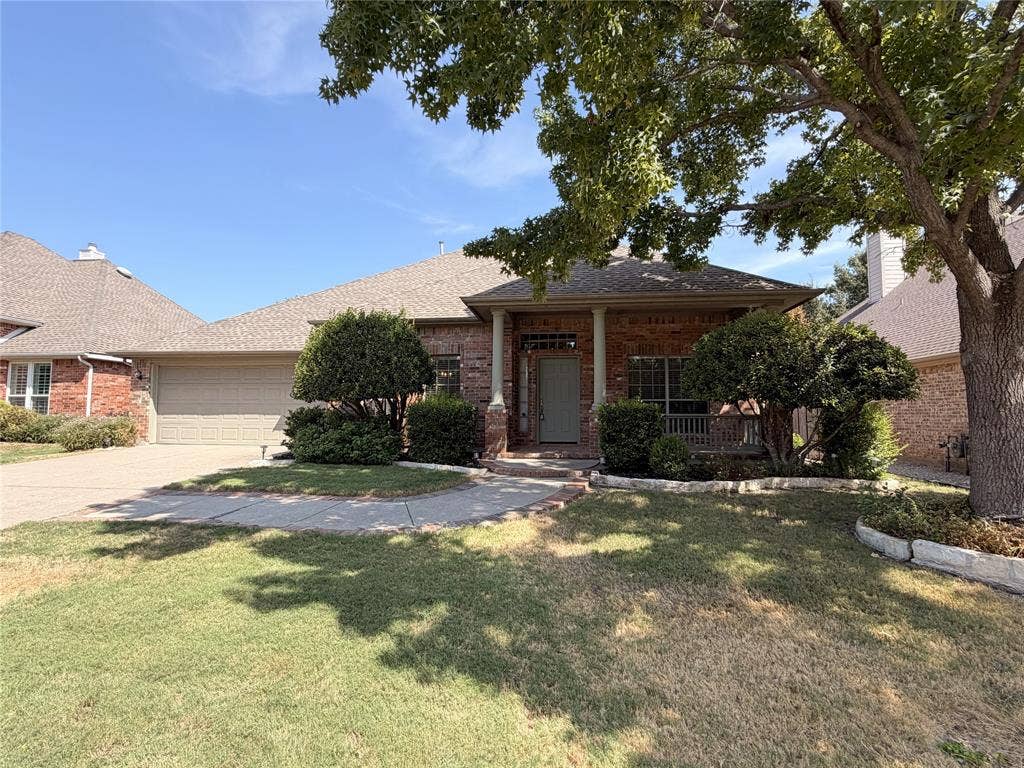 8100 Purple Martin Way, McKinney, TX 75072 Brick exterior with a covered entry, established landscaping, and an attached garage
