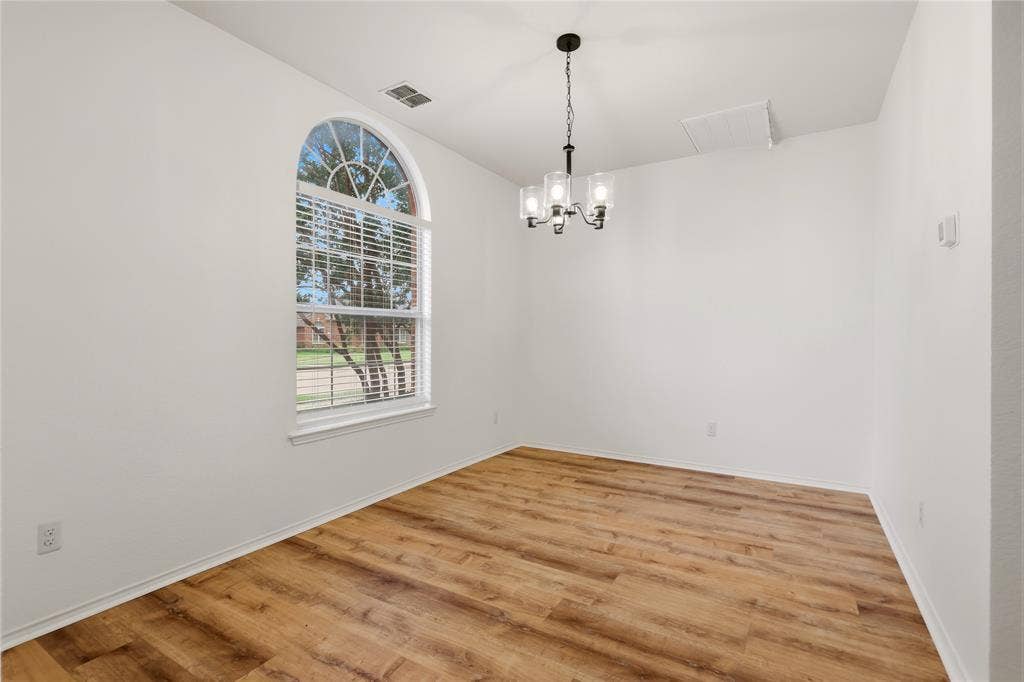 9105 Norman Drive, Plano, TX 75025 Arched window, wood-finish flooring, ceiling-mounted chandelier, crisp white walls