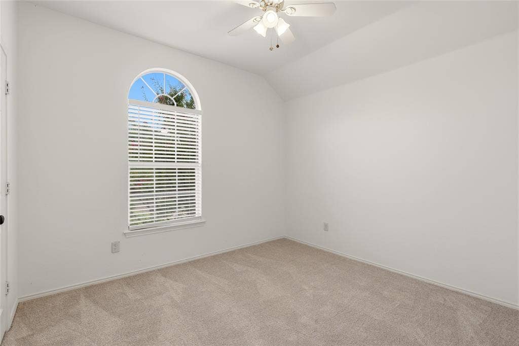 9105 Norman Drive, Plano, TX 75025 Vaulted ceiling, arched window, ceiling fan with integrated lighting, wall-to-wall carpeting, and white walls