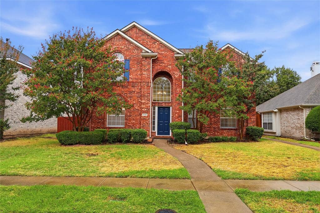 9105 Norman Drive, Plano, TX 75025 Brick exterior featuring a gabled roofline, arched window, and a dark blue entry door