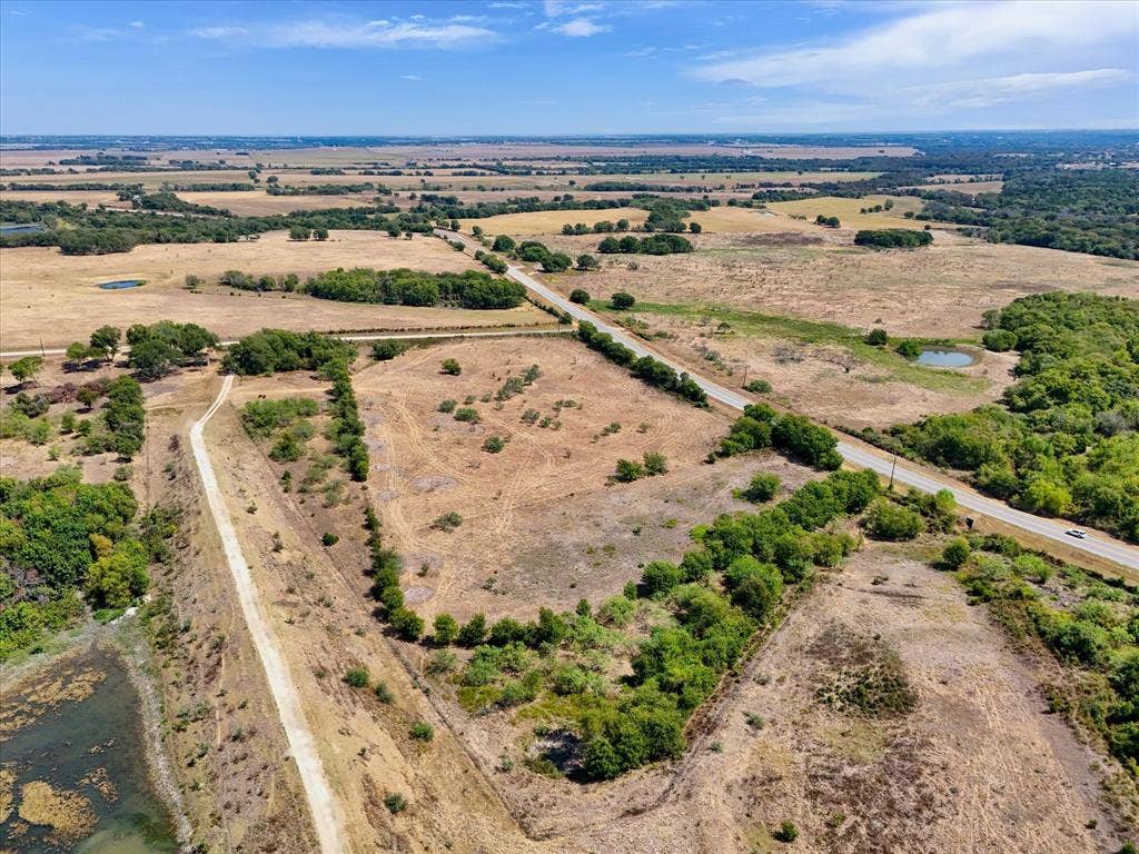 TBD Horne Hill Road, Moody, TX 76557 Expansive land parcels with scattered trees, a paved road, and a water feature