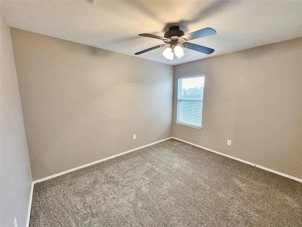 1229 Pine Forest Drive, Princeton, TX 75407 Neutral-toned walls complement the textured carpet flooring