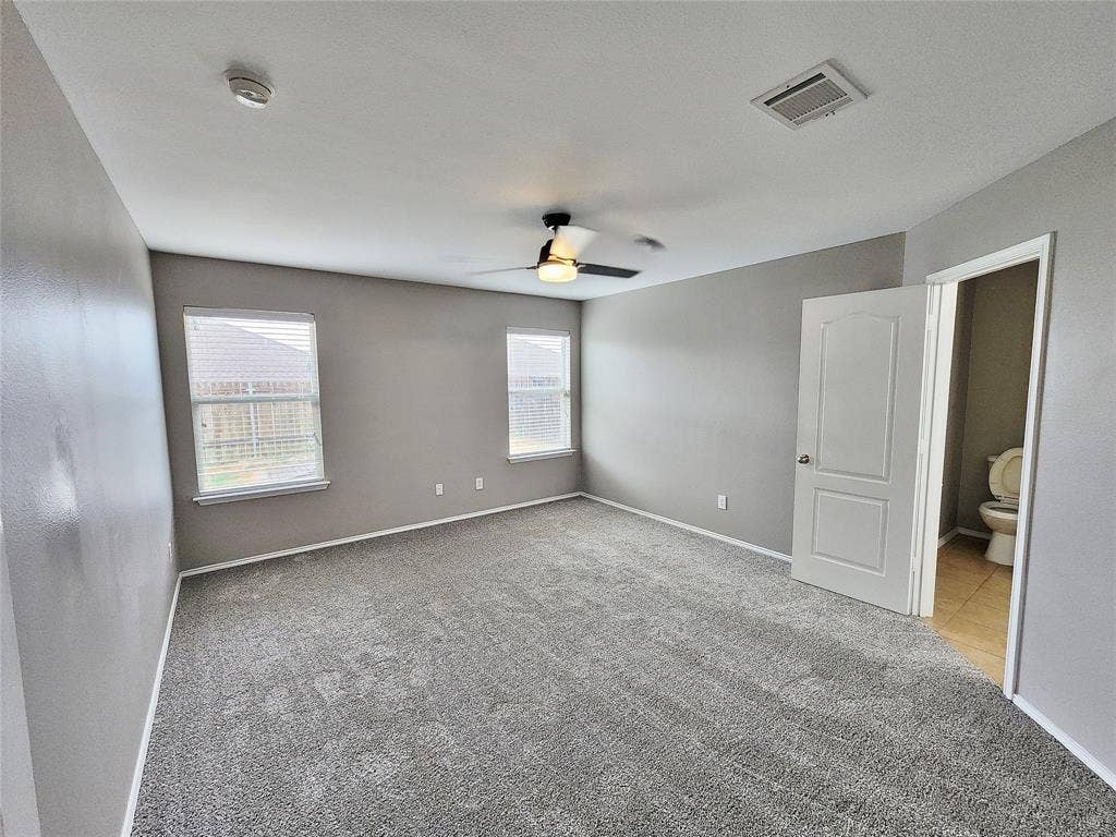 1229 Pine Forest Drive, Princeton, TX 75407 Spacious room with gray carpeting, multiple windows, and a ceiling fan