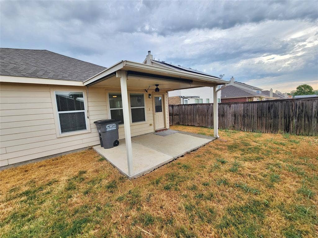 1229 Pine Forest Drive, Princeton, TX 75407 Covered patio with concrete slab, wood-paneled fence, and neutral siding