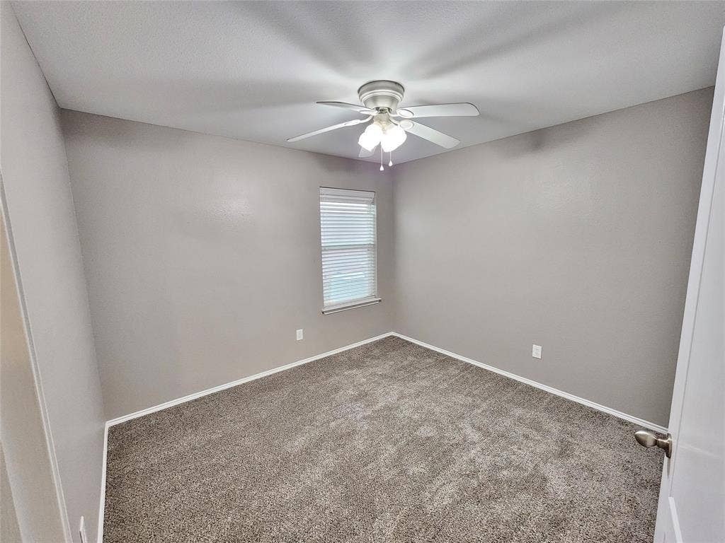 1229 Pine Forest Drive, Princeton, TX 75407 Neutral-toned walls, textured carpet flooring, ceiling fan with integrated lighting, and a window with blinds