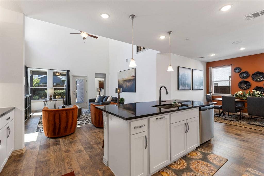1456 Kit King Drive, Little Elm, TX 75036 Modern kitchen island with dark countertop, white cabinetry, and a black gooseneck faucet
