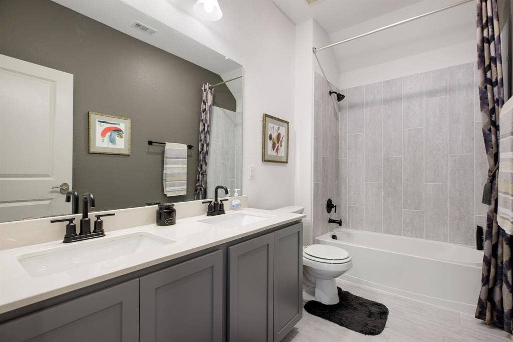 1456 Kit King Drive, Little Elm, TX 75036 Dual vanity with integrated sinks, light-toned countertop, and dark-finish faucets