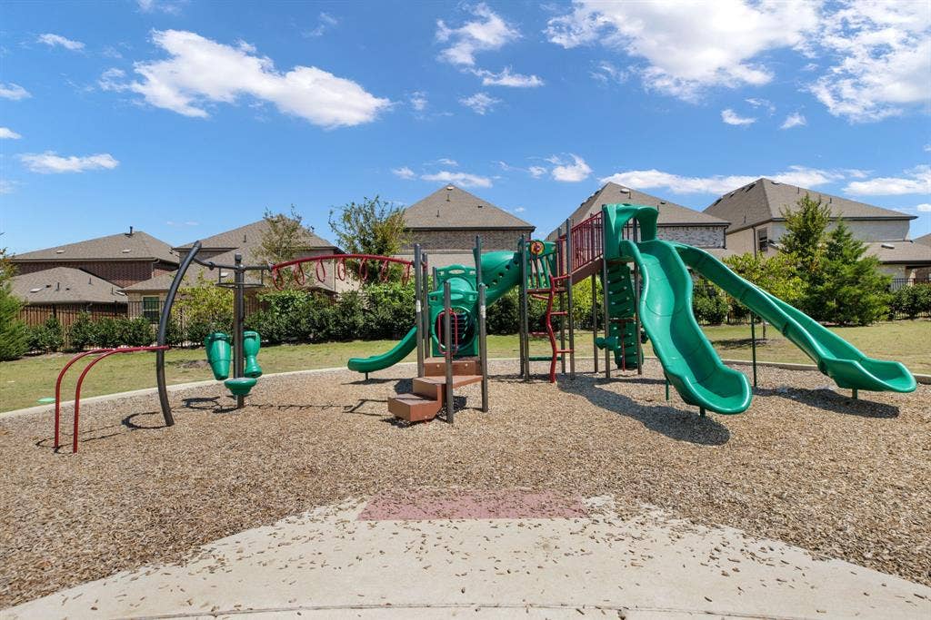 1456 Kit King Drive, Little Elm, TX 75036 Community playground featuring multiple slides, climbing structures, and a wood chip surface