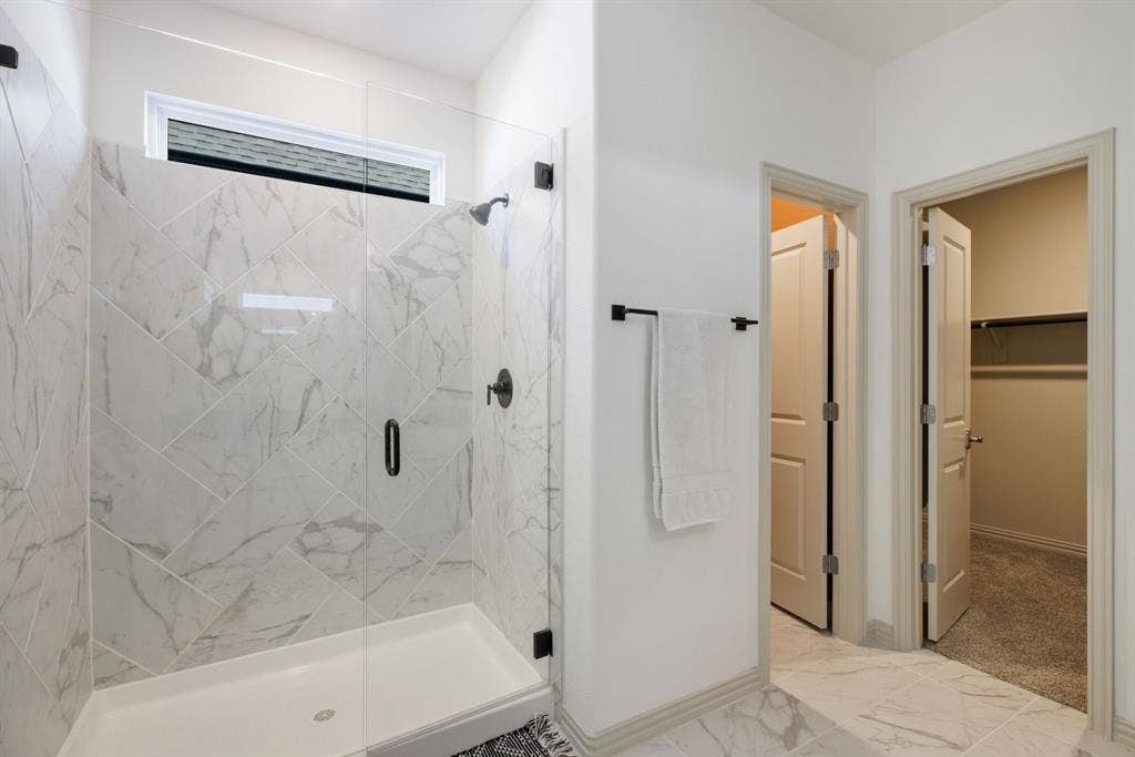 1456 Kit King Drive, Little Elm, TX 75036 Glass-enclosed shower with a white tile surround in a herringbone pattern and matte black fixtures