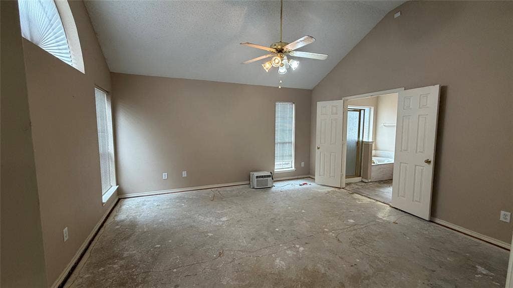 2718 High Pointe Boulevard, McKinney, TX 75071 Vaulted ceiling with a ceiling fan, dual windows, arched transom window, and a full bathroom with a soaking tub and separate shower
